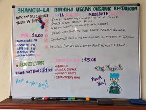 Menus are outside and inside on this whiteboard, changed twice a day at Shangri-la Buddha in Albany