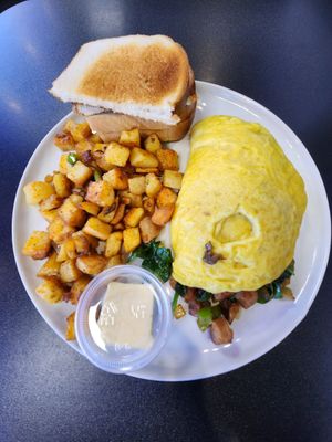Vegan omelet with spinach, onion, mushrooms, green pepper, vegan chicken, and vegan mozzarella cheese, and potatoes and toast on the side. at Black & Blue Diner in Las Vegas