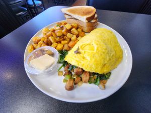 Vegan omelet with spinach, onion, mushrooms, green pepper, vegan chicken, and vegan mozzarella cheese, and potatoes and toast on the side. at Black & Blue Diner in Las Vegas