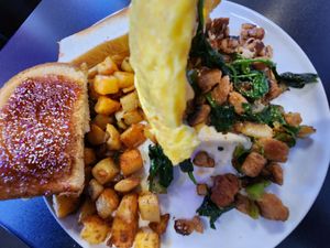 Vegan omelet with spinach, onion, mushrooms, green pepper, vegan chicken, and vegan mozzarella cheese, and potatoes and toast on the side. at Black & Blue Diner in Las Vegas