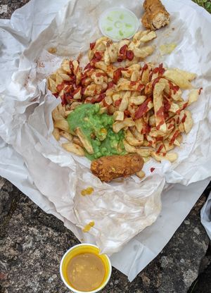 Chips with nice vegan battered sausage, nice vegan curry sauce, disappointing peas at Milton Chippy in Stoke-on-trent