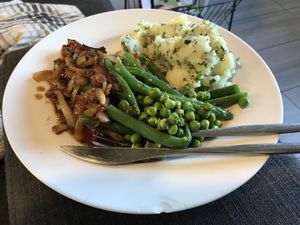 Sage and onion sausages, with onion gravy, smashed herby potatoes, beans and peas  at Green Dinner Table in Christchurch