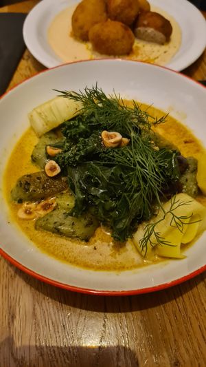 Smażone zielone kluski w sosie śmietanowym z curry, porem, orzechami laskowymi, jarmużem at Peaches Gastro Girls in Warsaw