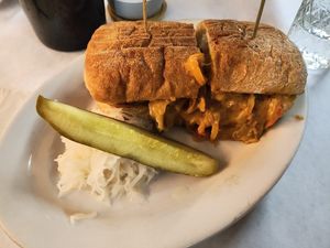 Delicious "Cheez Whiz” Philly Cheesesteak on rosemary focaccia, aquafaba mayo, sautéed seitan, caramelized onions /, peppers, melted house made cheddar cheese w/ kraut + pickle at The Organic Grill in New York City