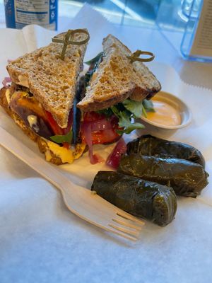 Black bean cheese burger with a side of grape leaves and extra chipotle aioli sauce on the side at The Hungry Caterpillar in Jacksonville