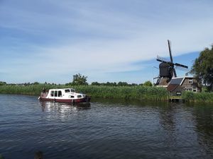 View from the cottage on the river with a typical dutch windmill. The water is clean to swim at De Groene Gevel in Woerdense Verlaat
