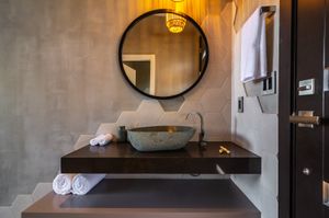 Natural honeycomb tiles and stones create your serene bathroom space at Mother Earth Vegan Hotel in Tamarindo