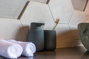 Natural honeycomb tiles and stones create your serene bathroom space at Mother Earth Vegan Hotel in Tamarindo