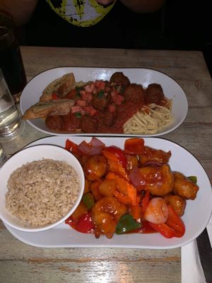 Orange chicken with veggies and rice. The other dish is spaghetti with meatballs. at Red Bamboo in New York City