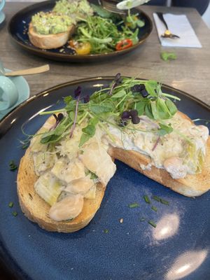 Leek and butter beans on toast with edamame on toast in the background   at Holy Cannoli in Blackburn