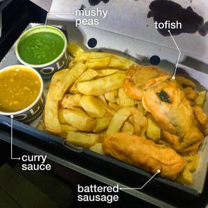 Tofish Meal with battered sausage, curry sauce, and mushy peas  at Golds Fish Chips & Vegan in Catshill