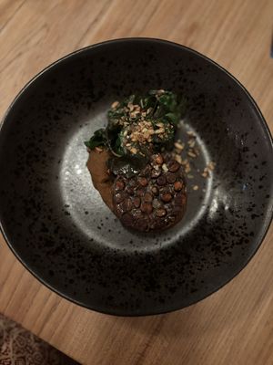 Grauwe erwtentempeh met gedehydrateerde pompoen, zwarte bonenmousse, snijbiet met geroosterde zonnenbloempitten  at Kasvio in Utrecht
