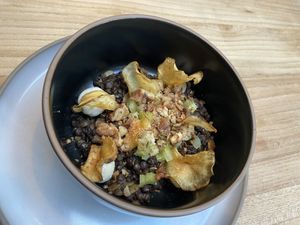 2nd starter: beluga lentils and pumpkin seed in Lapsang broth with lemon-almond ricotta, walnuts and chips. at Kasvio in Utrecht