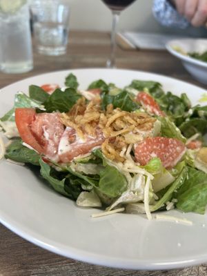 Caesar salad with fried onions and tomato added.   at PiANTA in Providence