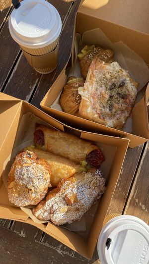 Front box: almond croissant & guava-cheese, Back: pizza pasty & ham-cheese croissants  at Chaumont Vegan in Beverly Hills