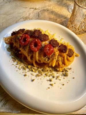 Vegan carbonara made with raspberry sauce, raspberry, pistachios’ crumble and smoked soy sausage.   at Vrindaa in Rome