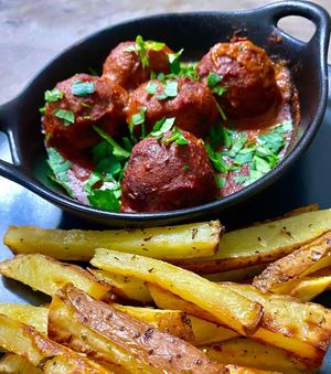 Veggie balls in red wine and tomato sauce served with oven backed potato wedges.Vegan and gluten free at Parsley and Thyme in Silves