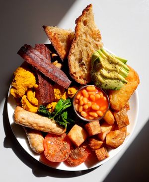 Slice + Dice Big Breakfast. B*con, scrambled curried tofu, roasted tomatoes,
spinach, s*usages, baked beans, fried potatoes,
avocado, mushrooms, hash browns + toasted
sourdough at Slice + Dice in Norwich