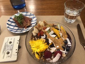 Açaí bowl with peanut butter topping, vegan bacon and a cassette deck with a QR code for the menu! Fits with the 80’s music playing and a retro vibe decor   at Faire Brunch & Drinks in Barcelona