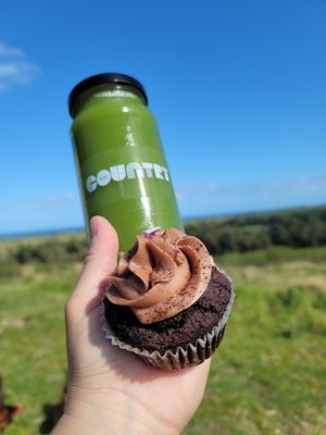 Deep greens cold pressed juice with a V+GF Chocolate cupcake.  at The Country Eatery in Kahuku