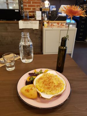 Squash pasta gratin with roasted beets, delicata squash topped some herbal sauce and a piece of focaccia. at Acorn Community Cafe in Eugene