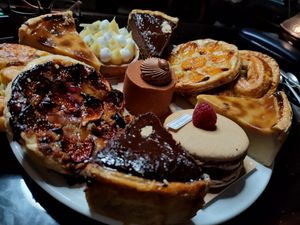 Plusieurs pâtisseries individuelles commandées chez Land&Monkeys: gâteau Hazelia au centre (choco noisette), entouré de parts de flan vanille, flan chocolat (un peu épais), ta at Land & Monkeys - Roquette in Paris