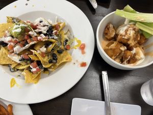 Pardon our diving in before I remembered to take a picture. Loaded nachos and cauliflower wings.  at Earth To Us in Raleigh