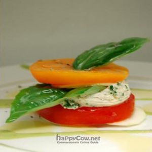 Third Course - Heirloom Tomatoes layered with thinly sliced Zucchini, Almond Cheese, Basil, drizzled with extra virgin olive oil and a rich basil oil at Karma in Northampton