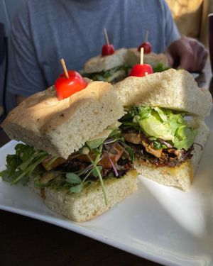 Badass vegan sammy in foreground, breaky-wich in background and lattes with oat milk on the side.   at The Roxy Cafe in Vernon