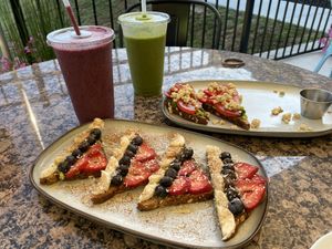 The avocado toast, our smoothies, and the other toast with the tomatoes and strawberries on it- I’m forgetting the name! 😂   at Real Roots Cafe in Chattanooga