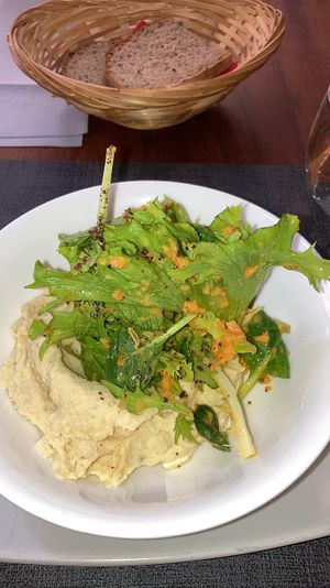 First: homemade hummus with greens and fennel dressing. Free bread   at Ca n'Ela Vegan Restaurant in Mallorca