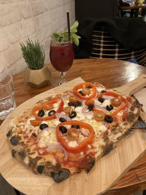 Very delicious and filling Greek pizza with Vegan Up juice  at Nomas in Macclesfield