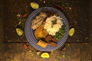 Virado a Paulista Vegano. White rice, bean tutu, grilled sausage on the grill, kale, breaded banana, seitan steak and crackling. at A Coruja in Sao Paulo