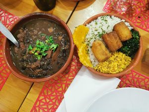 Feijoada🫘🫘 de seitan acompanhada de arroz, laranja🍊, banana🍌 frita, farofa e couve🥬. 🤤👌🏻 at Lanchonete A Casa in Barreiro