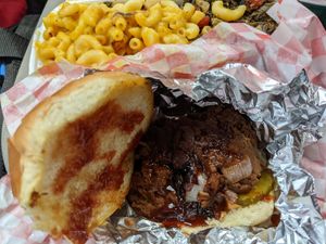 BarBQ jackfruit sandwich with sides of grilled Mac & cheese, mixed greens at Planet Vegan in Houston