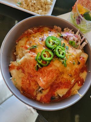 Birria enchiladas. This one was mine, it was excellent 💓 The bed of rice and beans is hidden beneath queso at Casa Del Vegano in Dallas