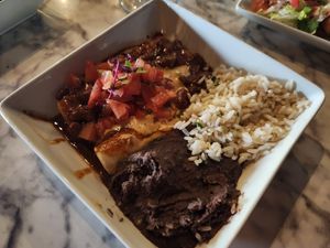 Cheese enchiladas topped with chili and queso with a side of rice and beans at Casa Del Vegano in Dallas