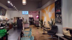 Booths in the back, high tables, bar & cushioned bench at Coconut Whisk in Minneapolis