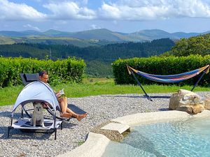 Hamacas para humanos y perros en la piscina at O Viso Ecovillage in Ourol