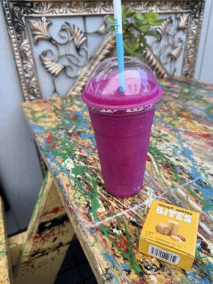 Dragon fruit smoothie made with almond milk, they gave me a vegan peanut butter bites to go along with it   at World Green Acai Bowl in Larkspur