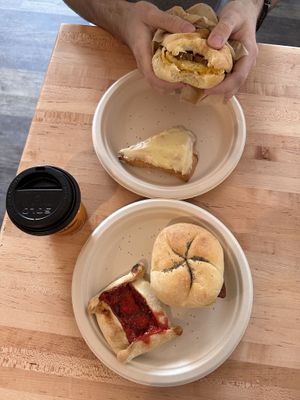Breakfast sandwich: egg, cheese, bacon, and ketchup on Kaiser roll ($9), orange scone ($4), strawberry rhubarb crostata ($7), 8oz drip coffee ($3.50)   at New Moon Vegan in Batavia