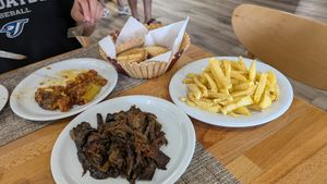Aubergine, fries, stuffed peppers (already being eaten) at Eni Traditional Food in Berat