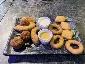 Sample platter with onion rings, bitterballens, fried avocado, and nuggets- with honey mustard and mayo.  at Vegan Temple Bar in Amsterdam