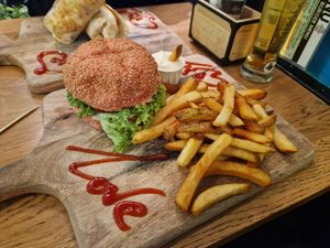 Truffle burger on pink bun with fries and mayo at Vegan Temple Bar in Amsterdam