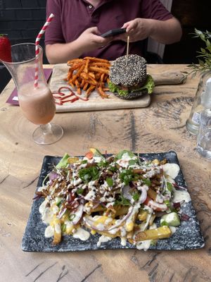 Hamburguesa de pan negro y patatas con smoothie de plátano y fresa.  at Vegan Temple Bar in Amsterdam