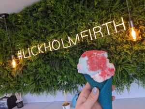 Raspberry ripple topped with candyfloss and sherbet in a colourful cone at Lick in Holmfirth