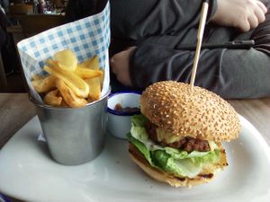 Vegan burger and chips. Contains mock meat style patty and vegan cheese. Had a decent meaty texture if you like that kind of thing. Chips are cut in a weird way so they're curved. at Perch on Lancing Beach in Lancing