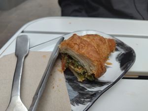 Eine Hälfte des belegten Croissants (mit veganem Mozzarella, Pesto und Gemüse) at Shluk in Trier