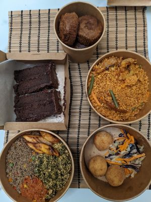 Spinach stew, jollof, yam balls, chocolate cake, carrot muffins. at Veghana in Dubai
