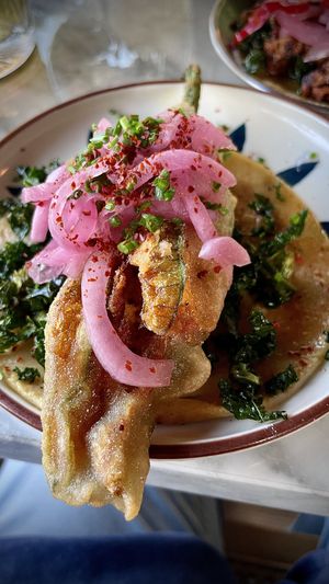 SQUASH BLOSSOM
lightly fried squash blossom stuffed with vegan chihuahua cheese, crispy kale, pickled onion, aleppo, sumac, chives  at Tu Madre in West Hollywood